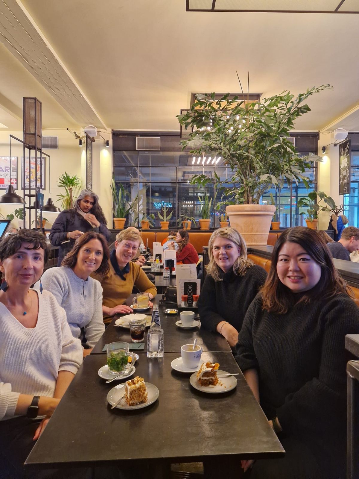 A small group of members having tea and carrot cake together in a café