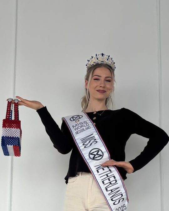 Charlotte Boonstra, Miss World Netherlands 2025, wearing her sash and crown and holding a red, white and blue beaded bag